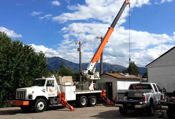A truck with a crane attached to the back of it