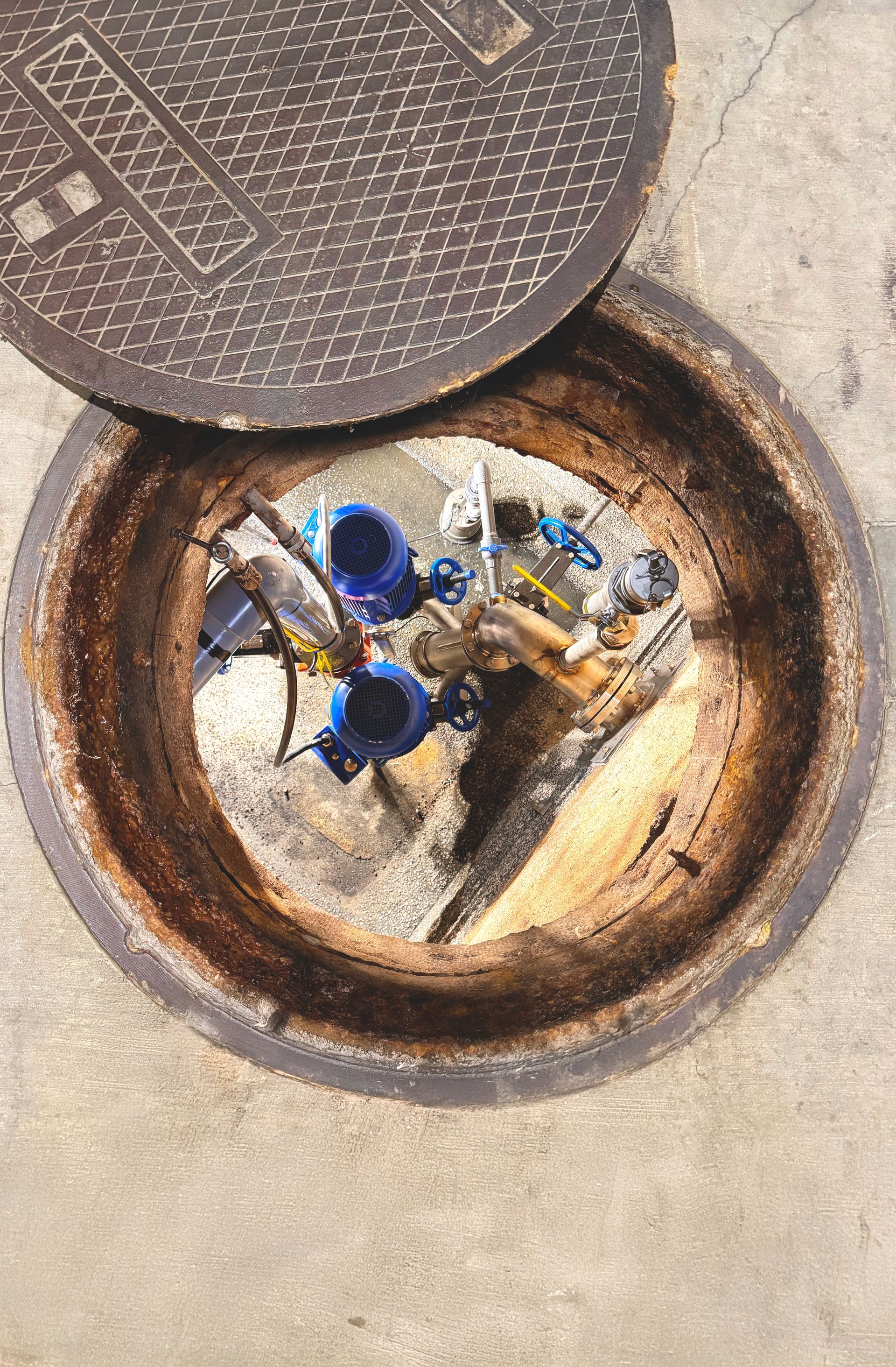 A manhole cover with a pump system inside of it.