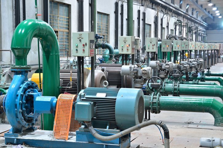 A row of pumps and pipes in a factory.