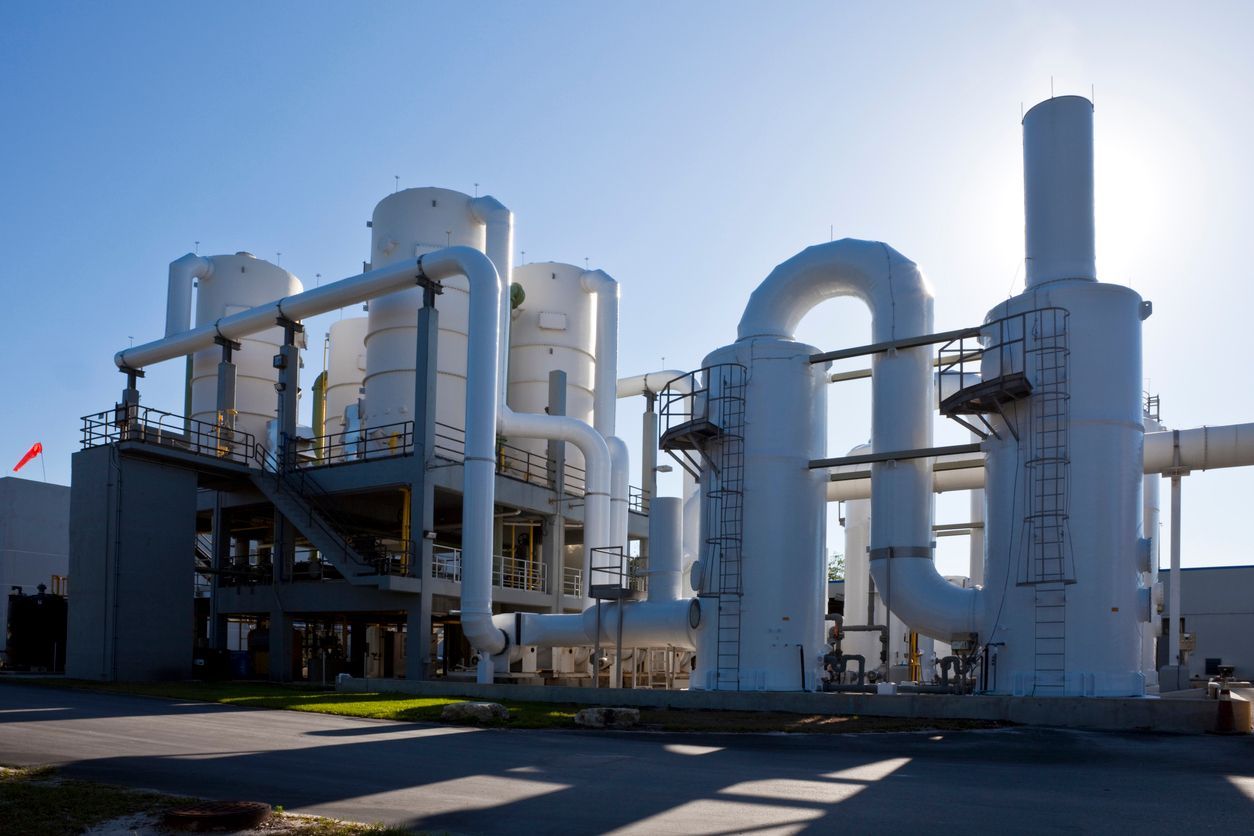 A large industrial plant with a lot of pipes coming out of it.