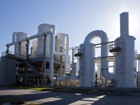 A large industrial plant with a lot of pipes and chimneys.