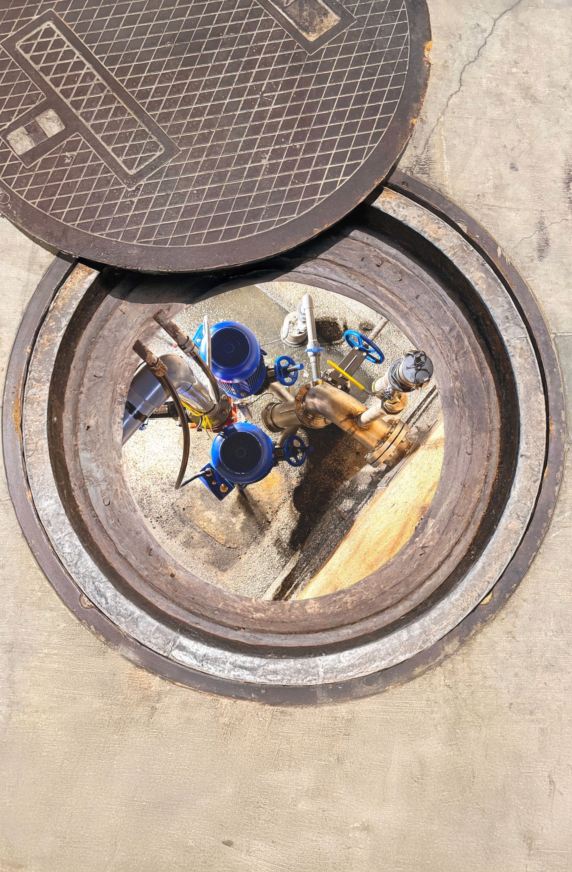 A blue pipe is coming out of a hole in the ground.