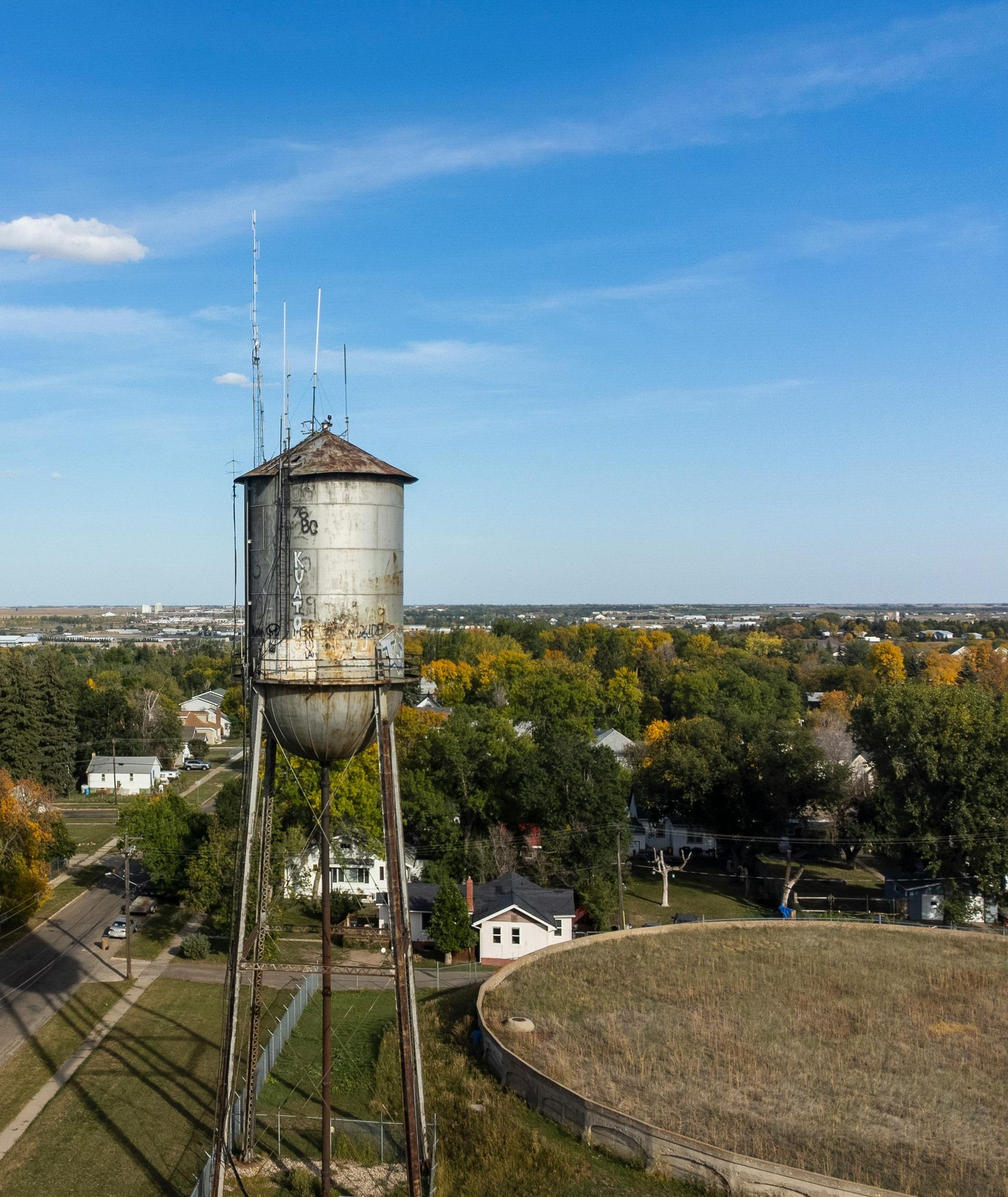 A large splash of water is coming out of a hole in the ground.