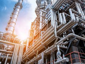 A large industrial plant with lots of pipes and chimneys.