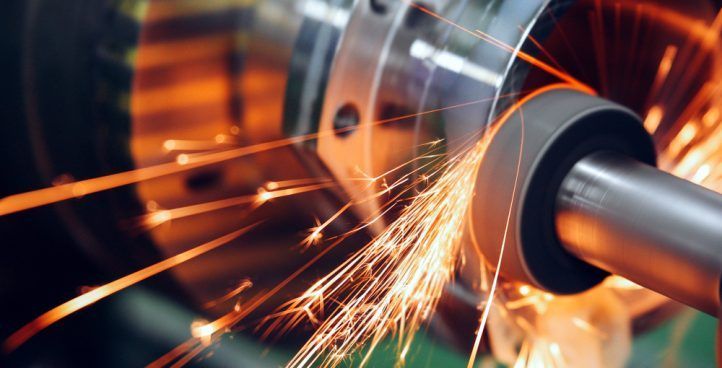 A machine is cutting a piece of metal with sparks coming out of it.