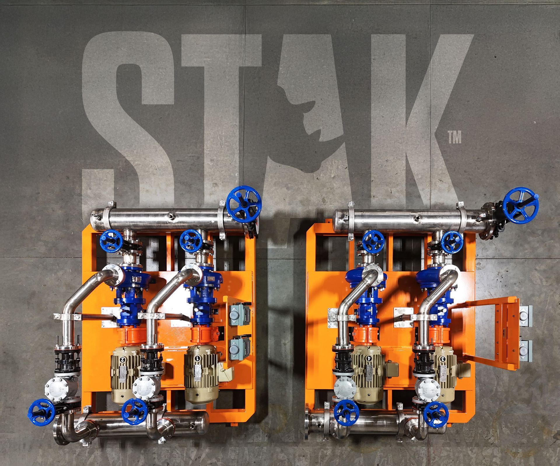Two orange mechanical devices with blue wheels on a gray floor beneath a STK logo