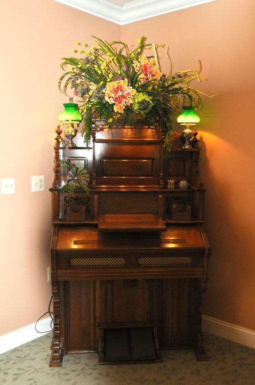 A desk with a lamp and flowers on top of it