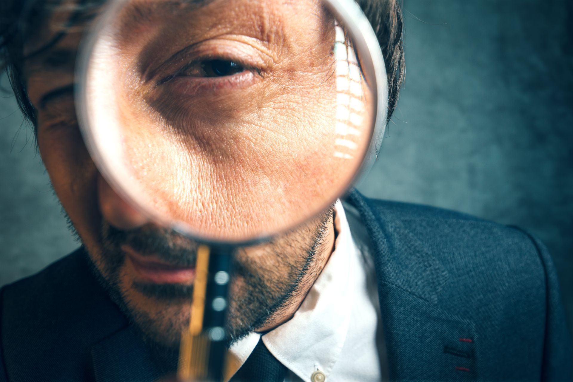 Man looking through a magnifying glass