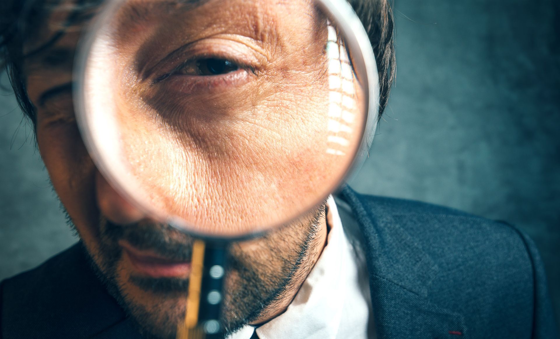 Man looking through a magnifying glass