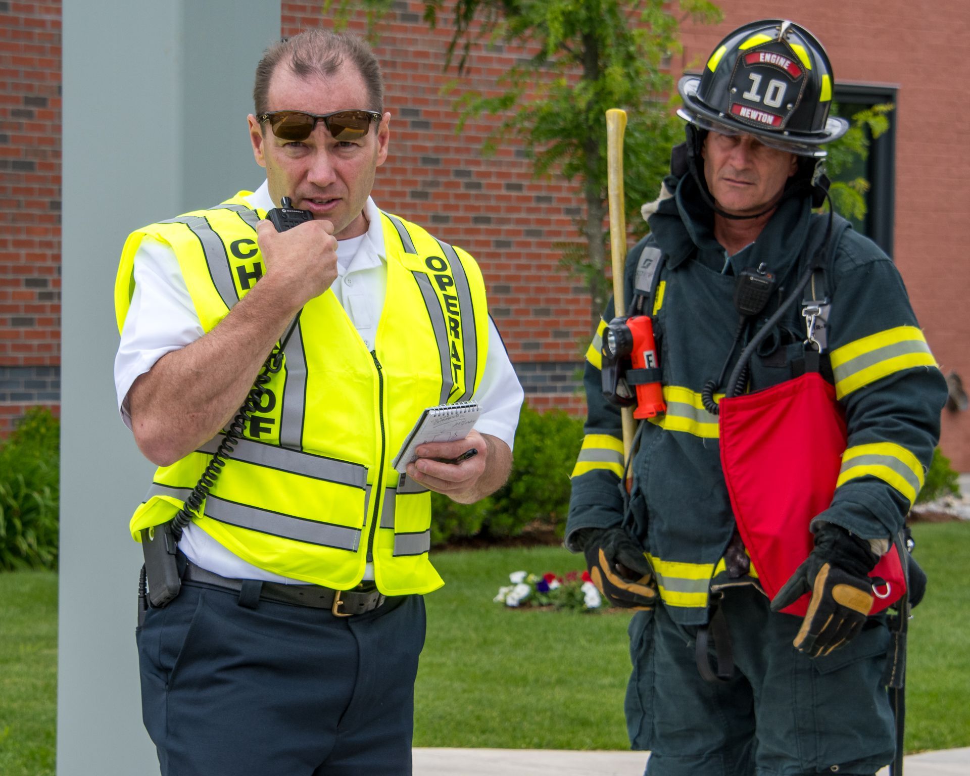 Chief of Operations and firefighter communicating via two-way radio during an active shooter exercise