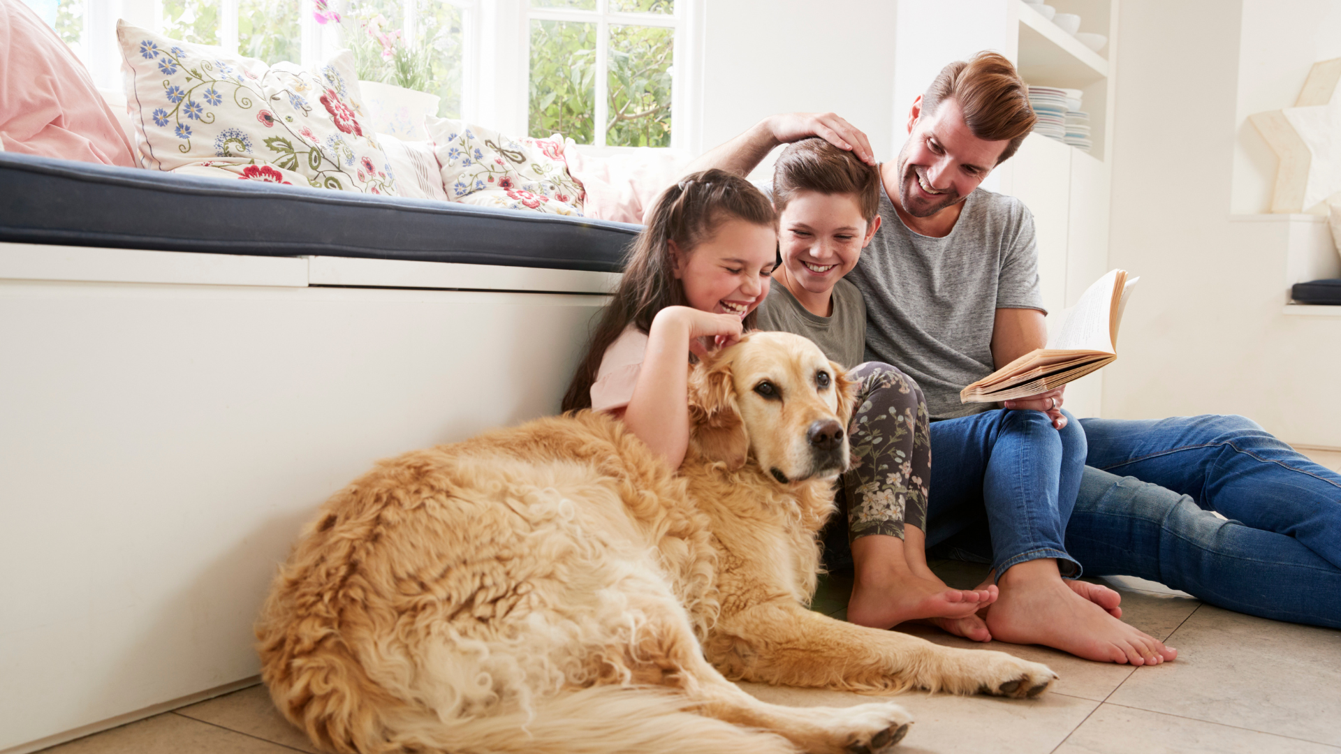 A family is sitting on the floor with a dog.