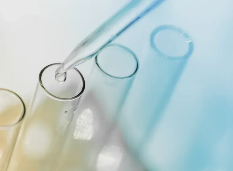 A drop of liquid is being poured into a test tube