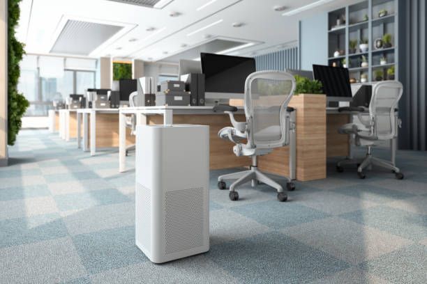 An office with a air purifier in the middle of the room.