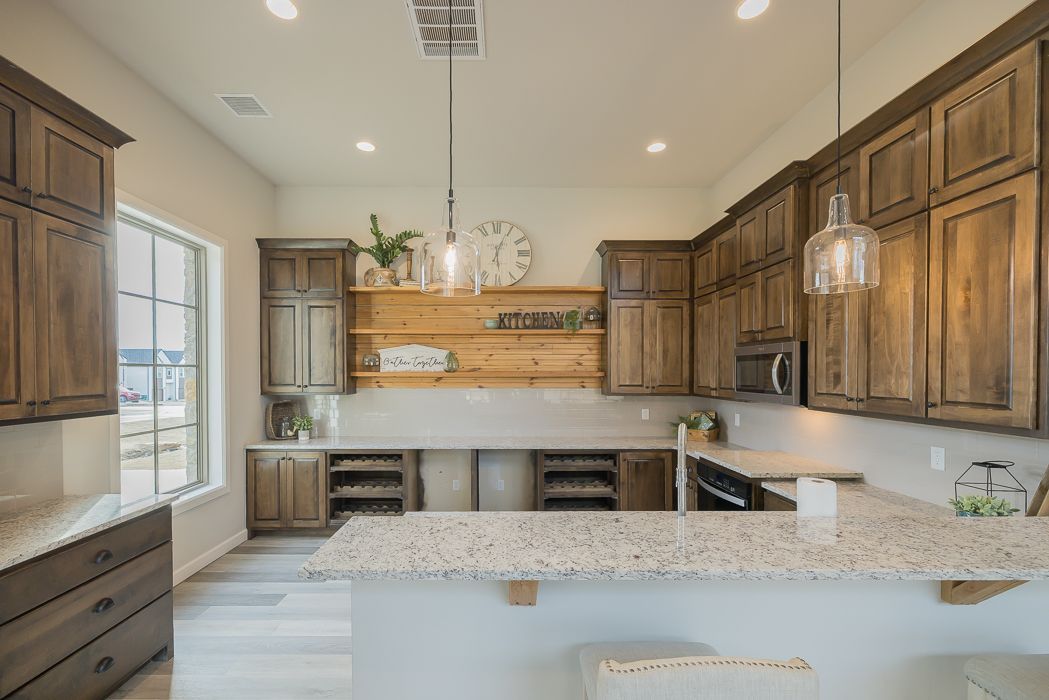 Kitchen with light countertops, dark wood cabinets, and a wood shelf.