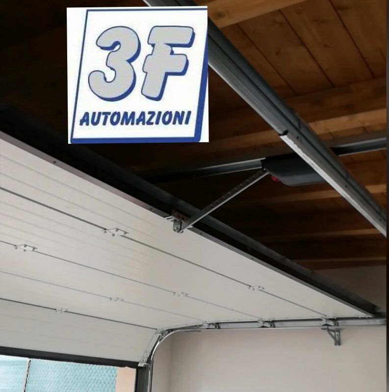 Porta da garage automatica, pannelli bianchi, montata a soffitto.