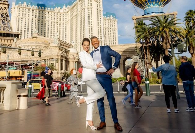 Couple poses for photo in front of the Eiffel Tower replica in Las Vegas.