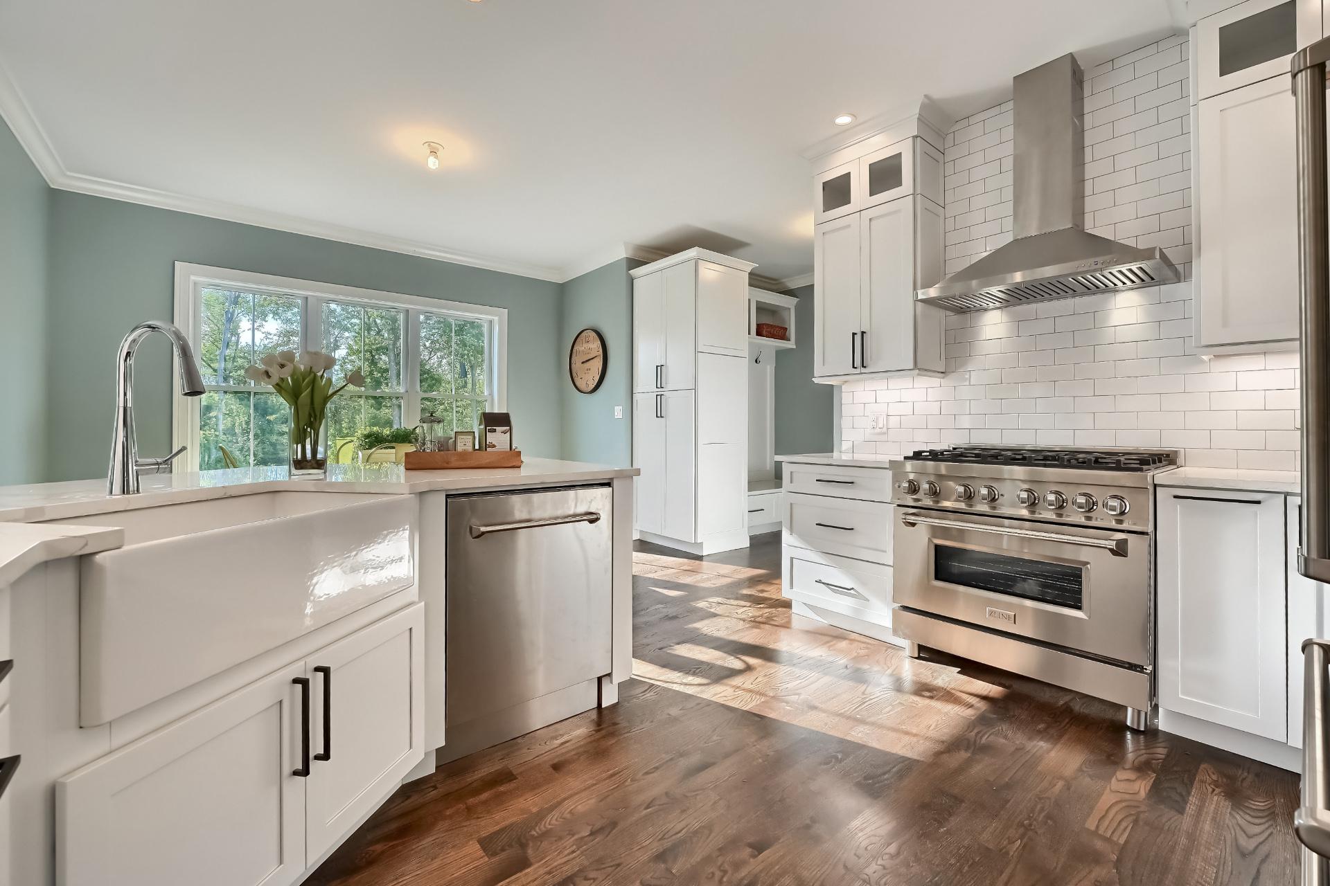 A kitchen with white cabinets and stainless steel appliances