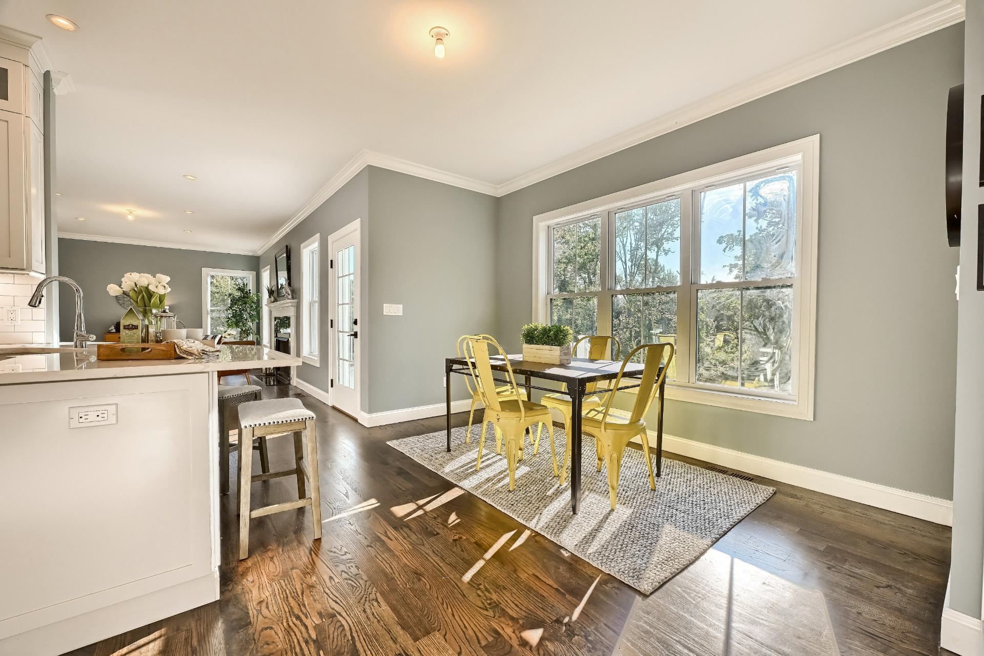 A dining room with a table and chairs and a large window.