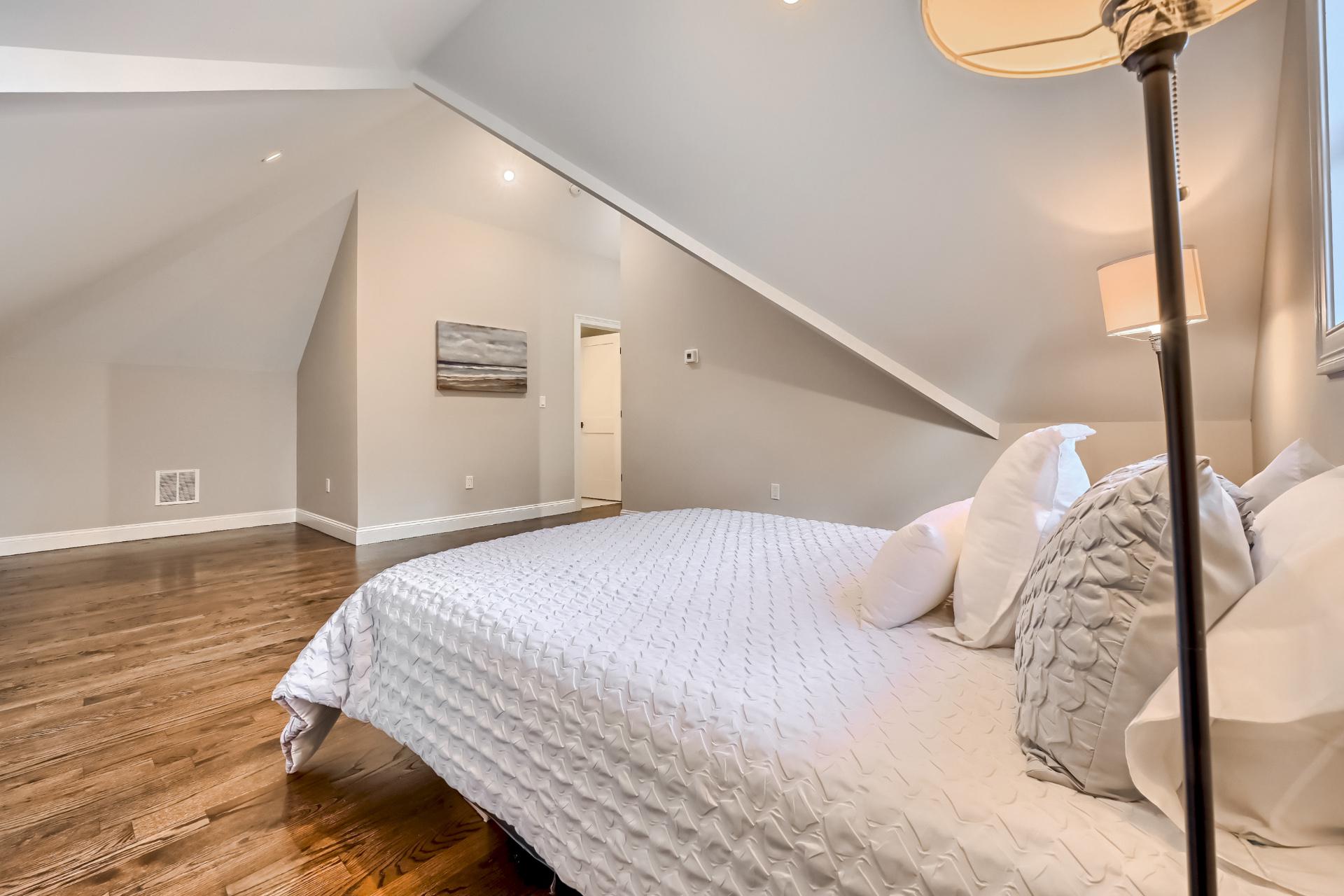 A bedroom with a king size bed and a lamp.