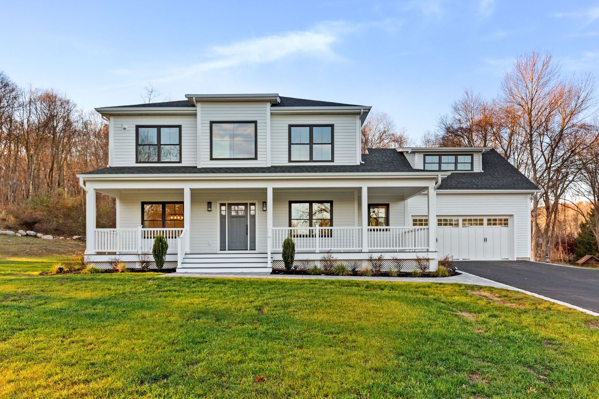 A large white house with a porch and a garage