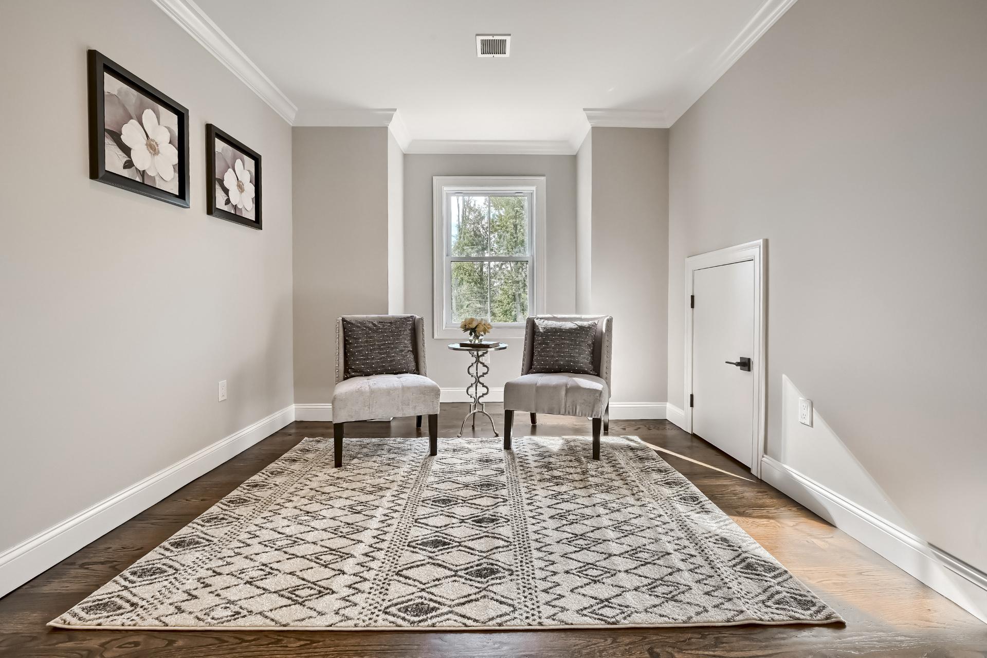 A living room with two chairs and a rug.