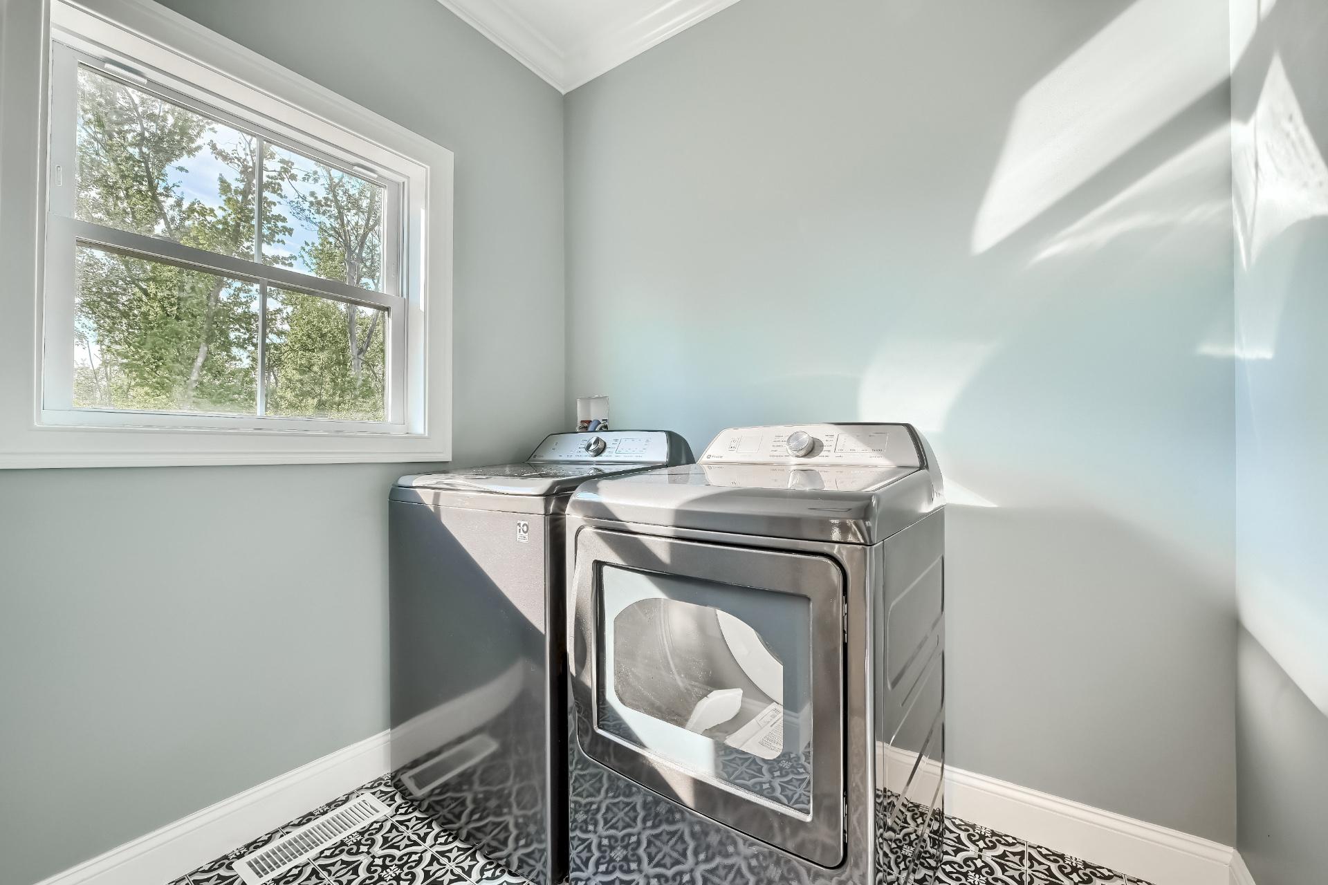 A laundry room with a washer and dryer and a window.