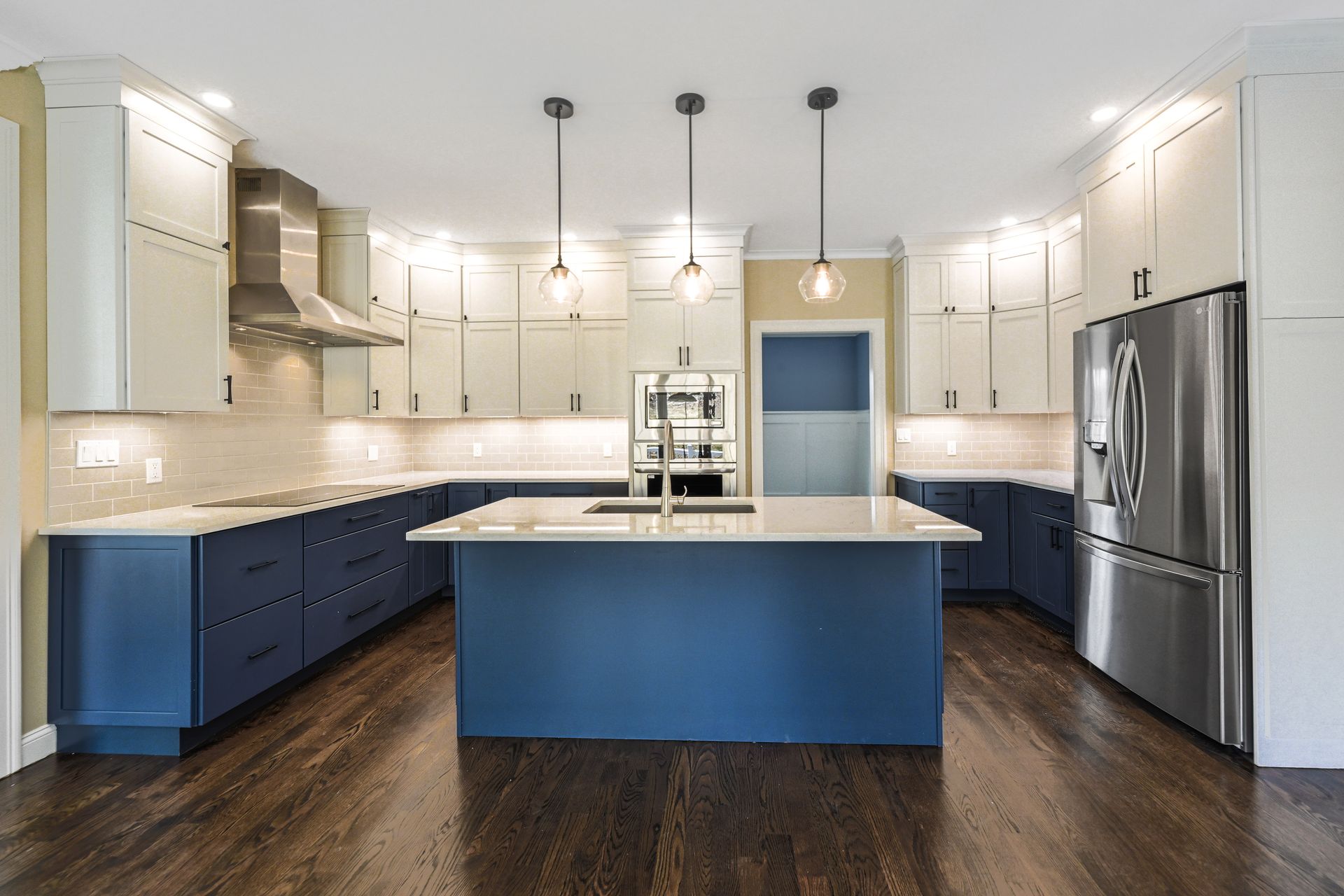 A kitchen with blue and white cabinets and stainless steel appliances
