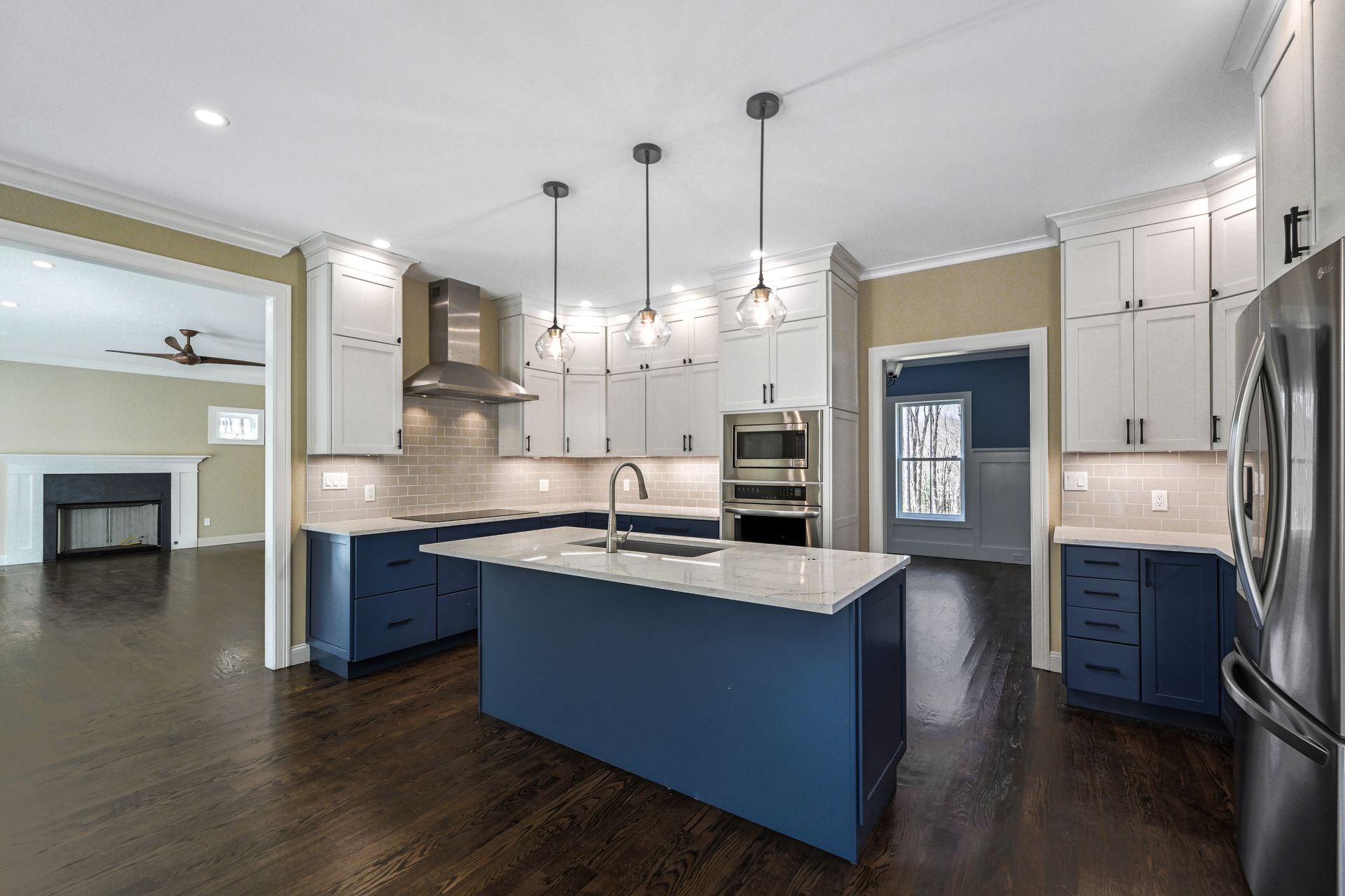 A kitchen with blue cabinets , white cabinets , and stainless steel appliances.
