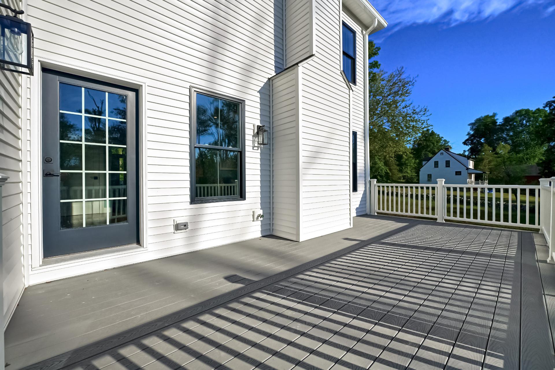 A large white house with a patio and a white railing.