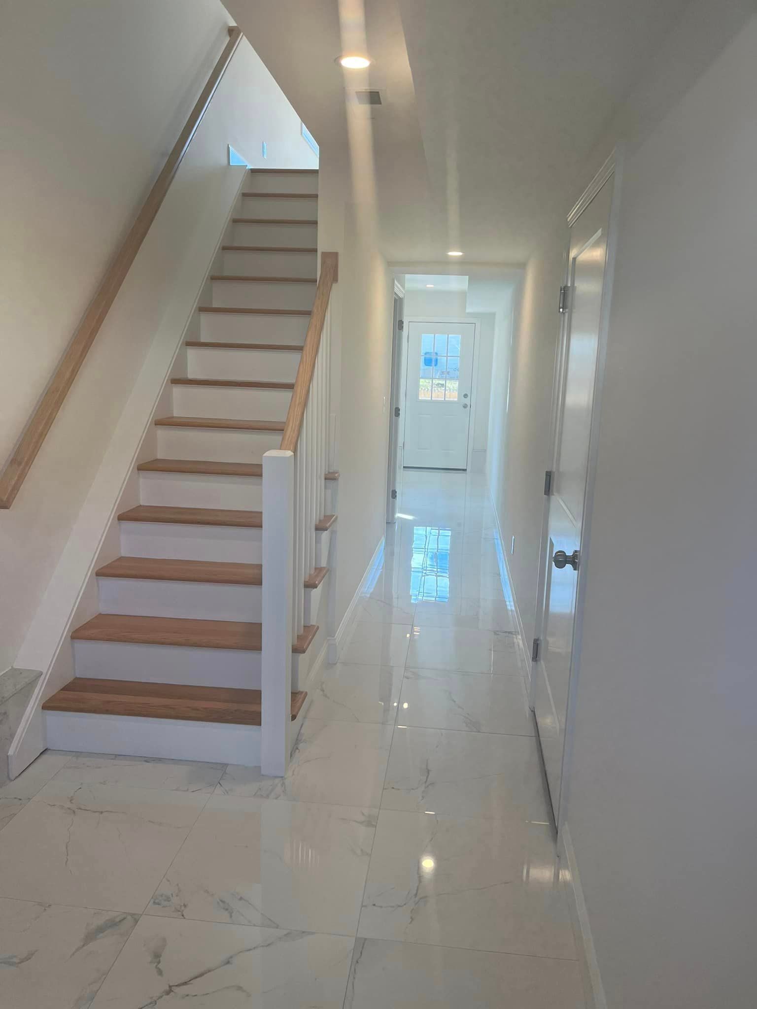 A hallway with stairs leading up to the second floor