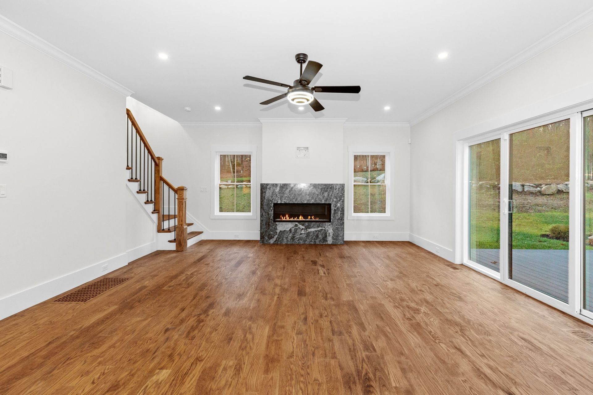 An empty living room with hardwood floors and a fireplace