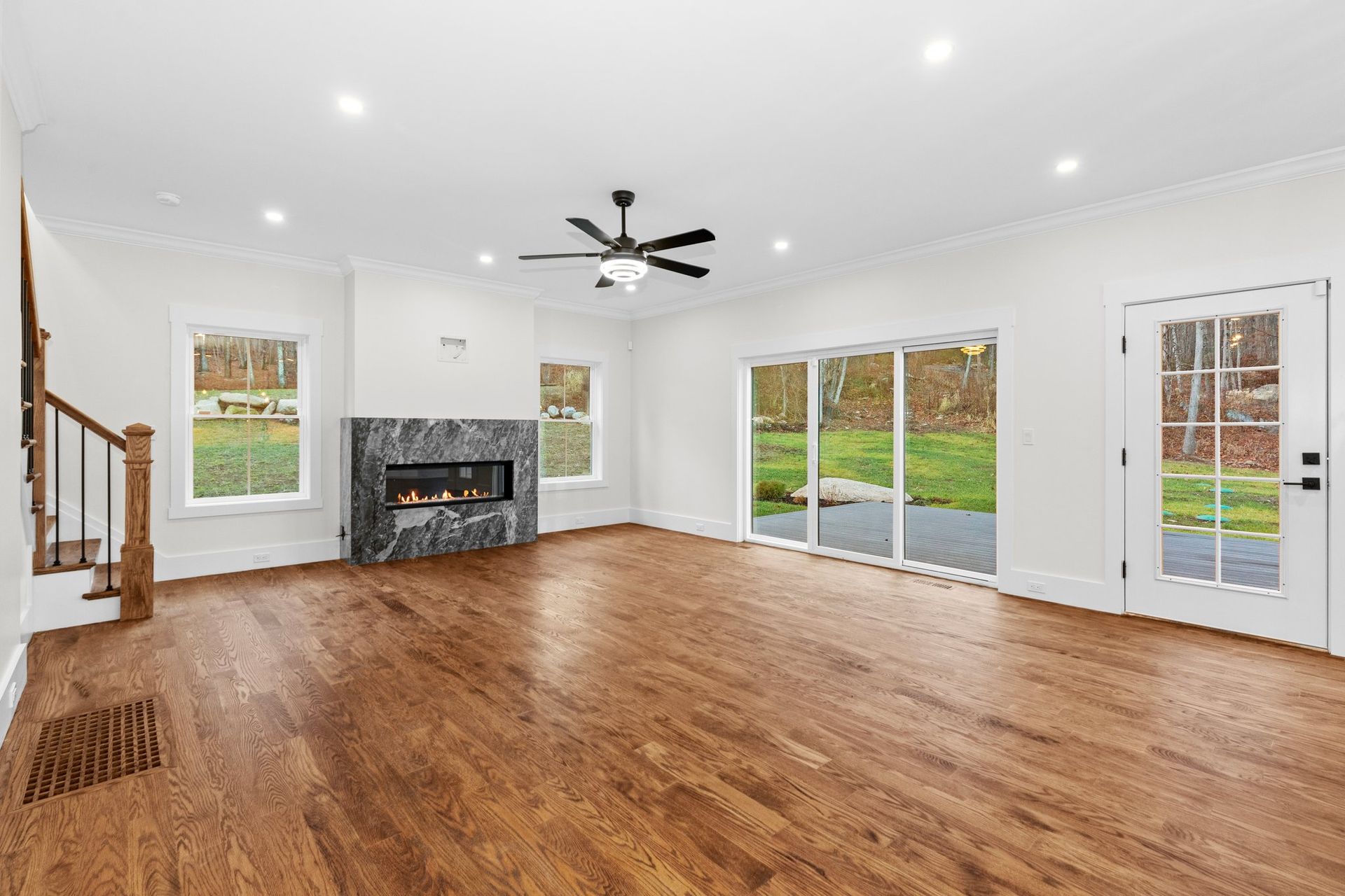 An empty living room with hardwood floors and a fireplace