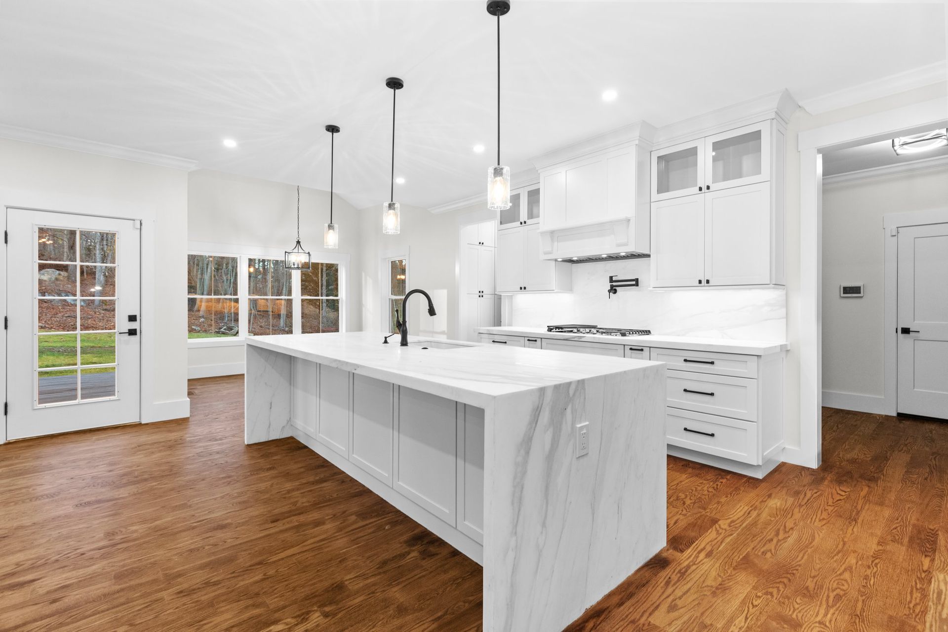 A kitchen with white cabinets and a large island