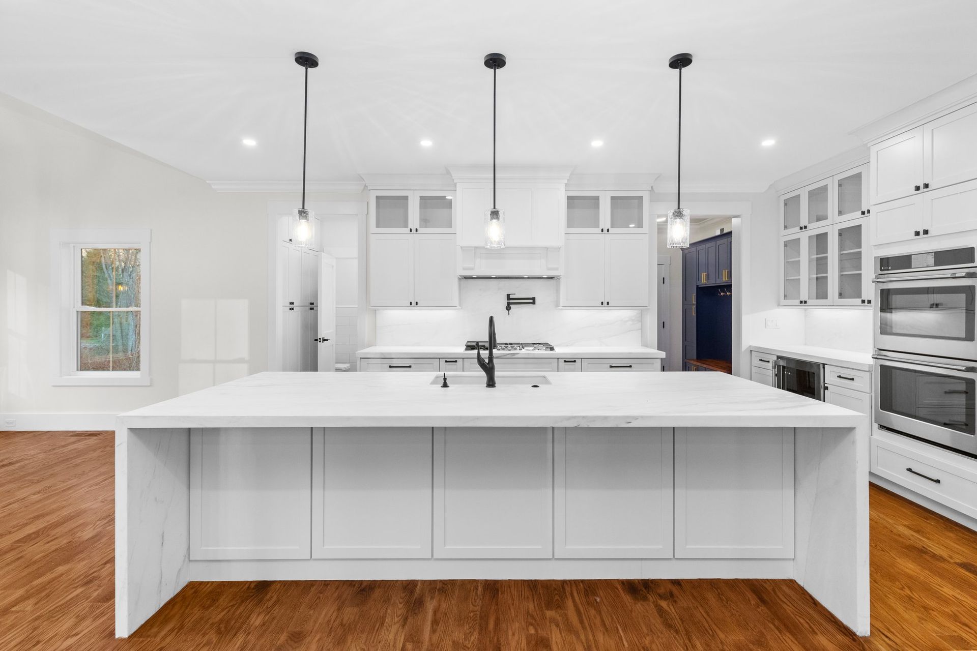 A kitchen with white cabinets and a large island