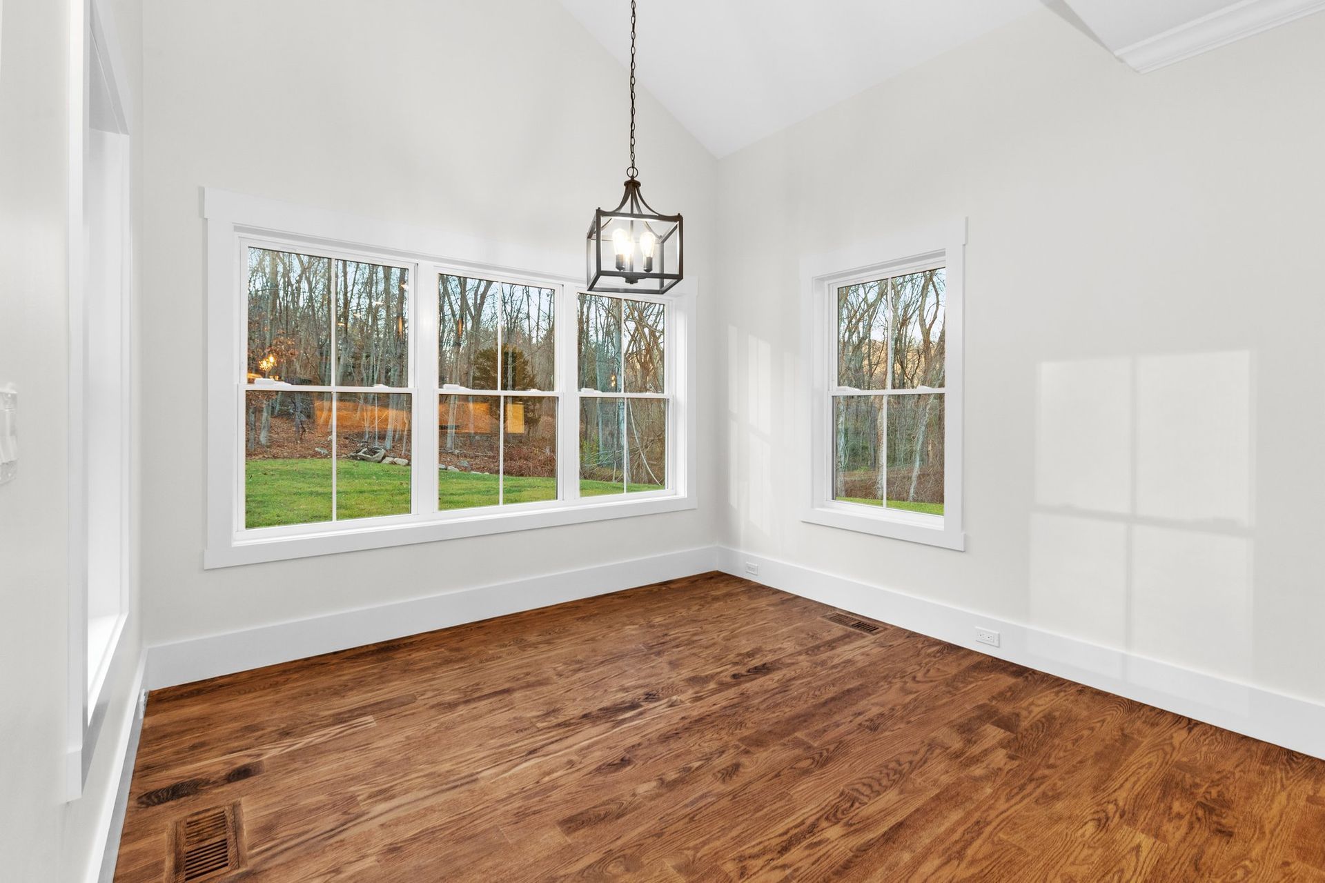 An empty room with hardwood floors and white walls