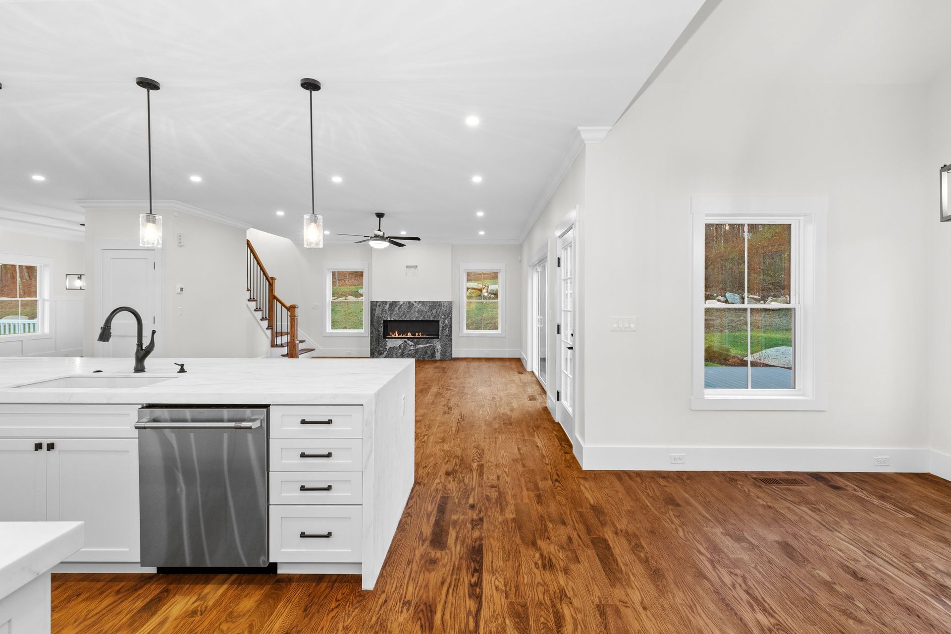 A kitchen with hardwood floors and white cabinets
