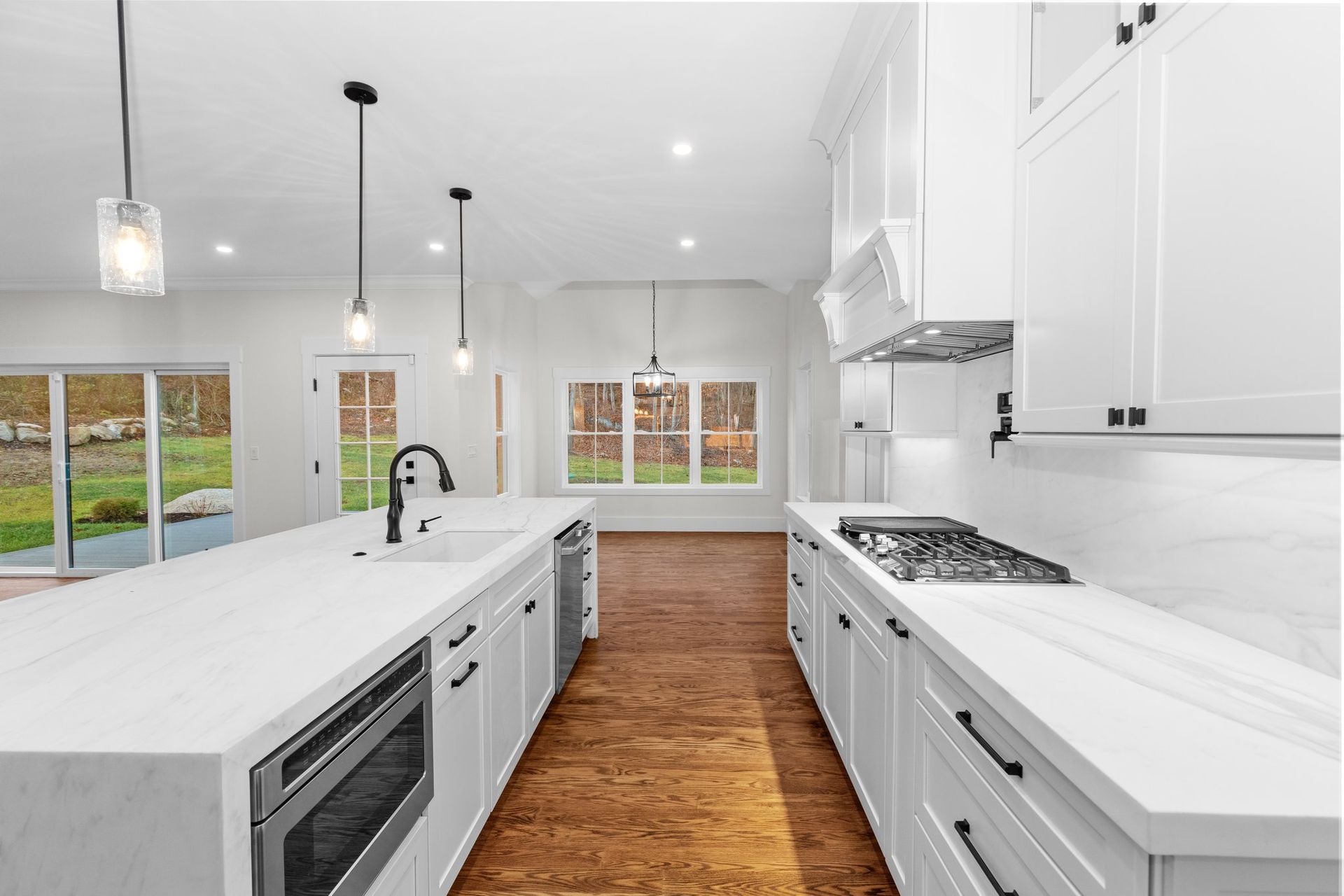 A kitchen with white cabinets and hardwood floors