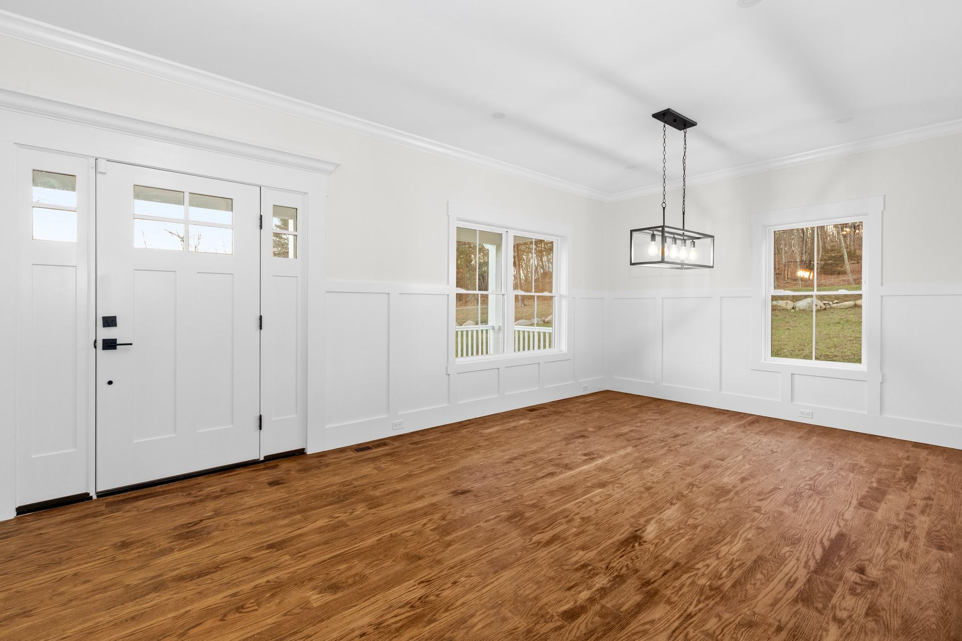 An empty room with hardwood floors and white walls