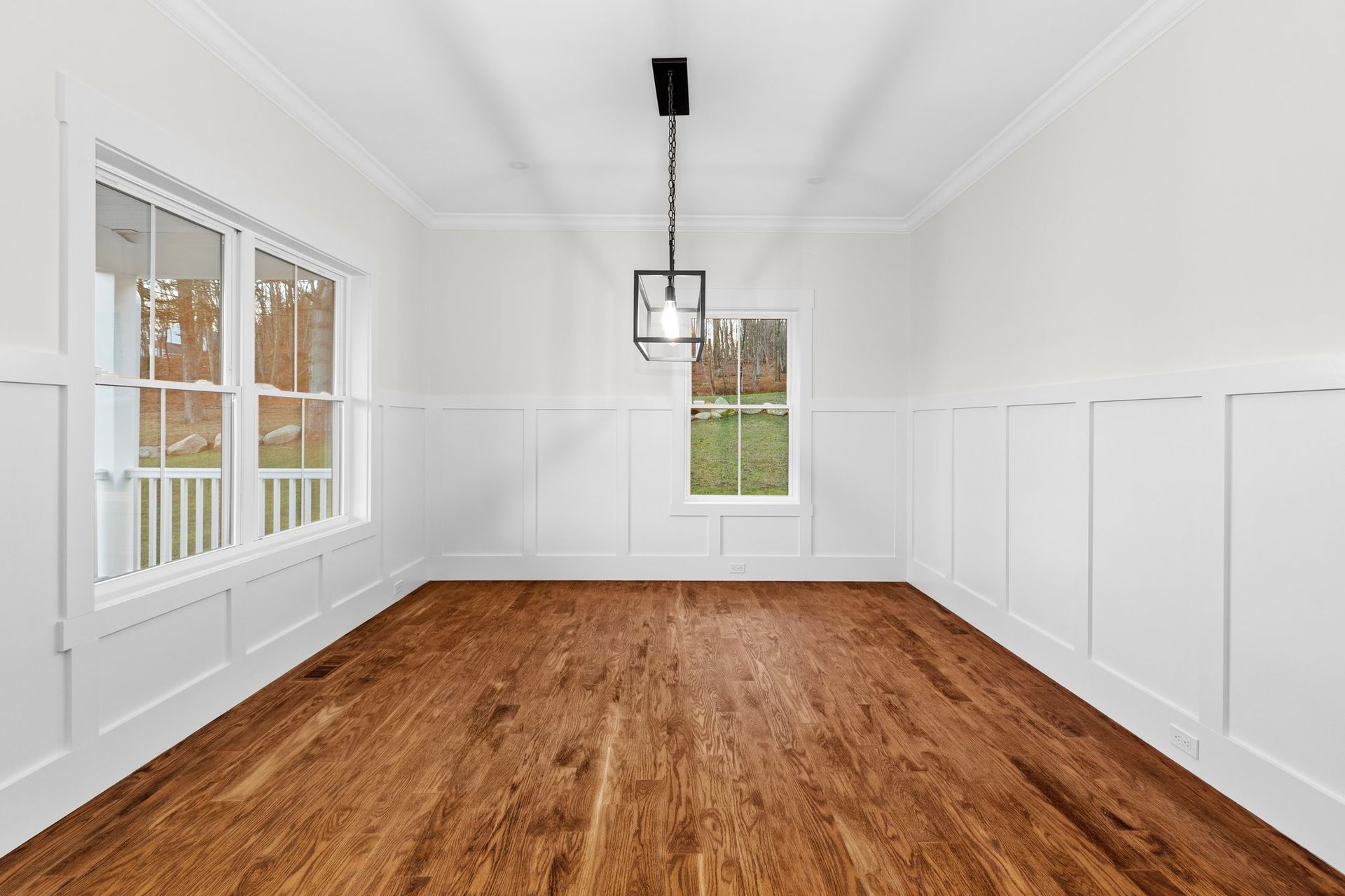 An empty room with hardwood floors and white walls