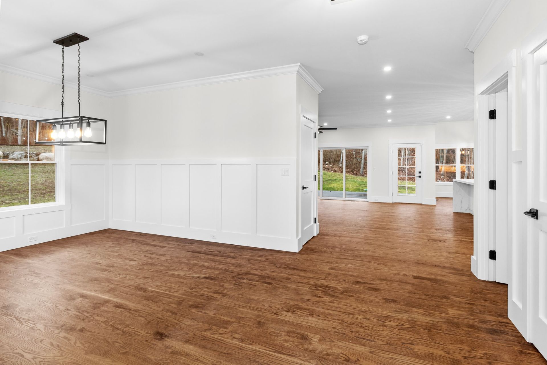 A large empty room with hardwood floors and white walls