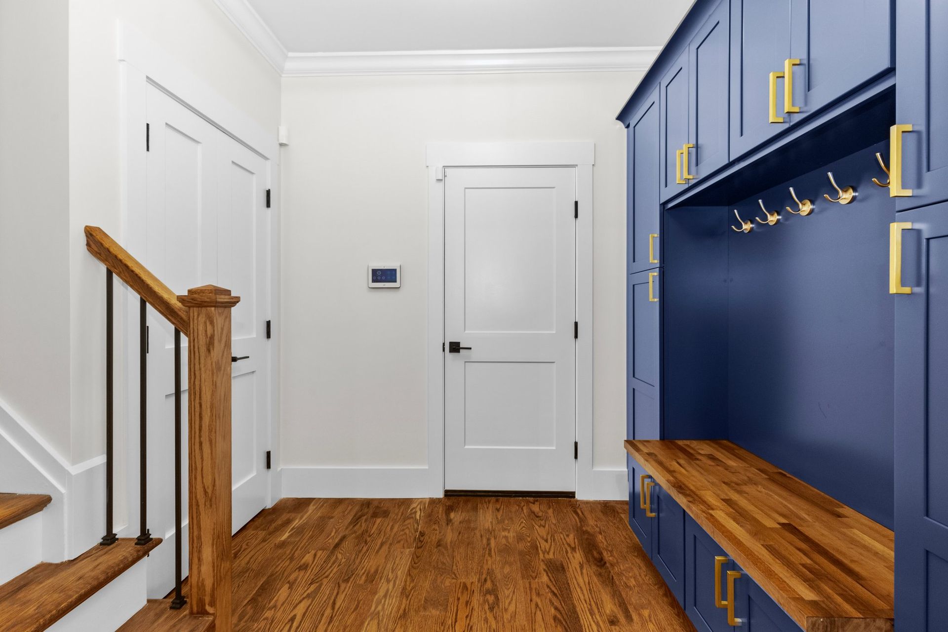 A hallway with blue cabinets and a wooden bench