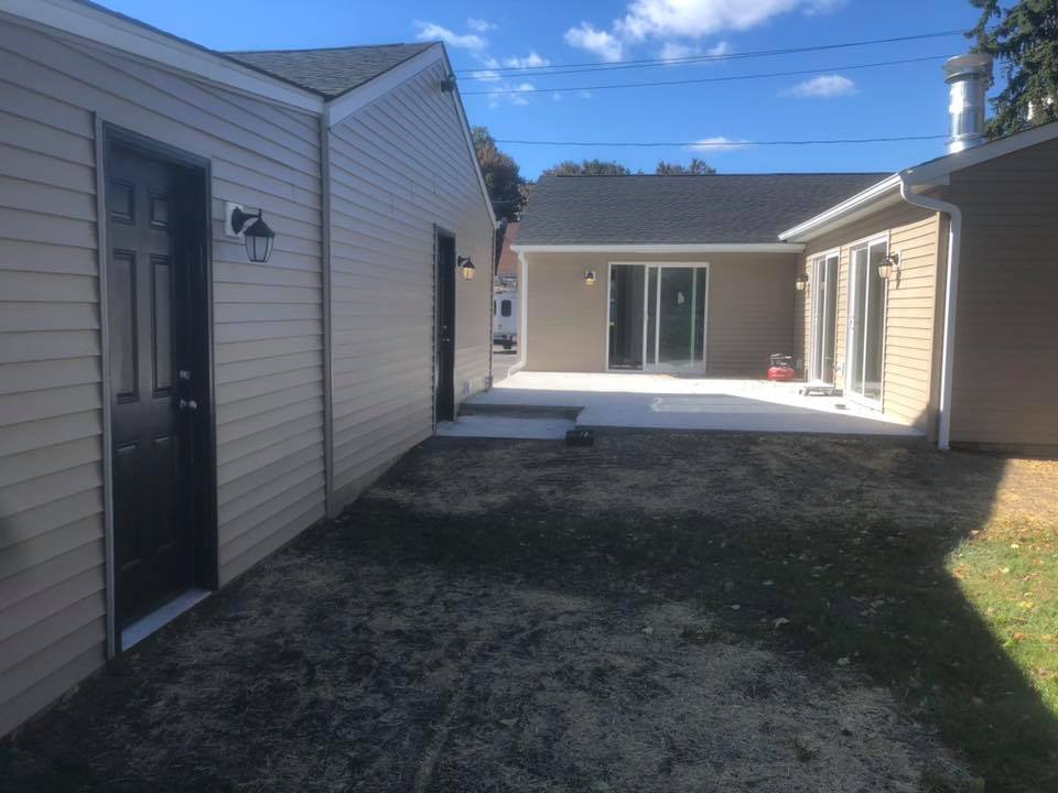 The backyard of a house with a patio and a sliding glass door.