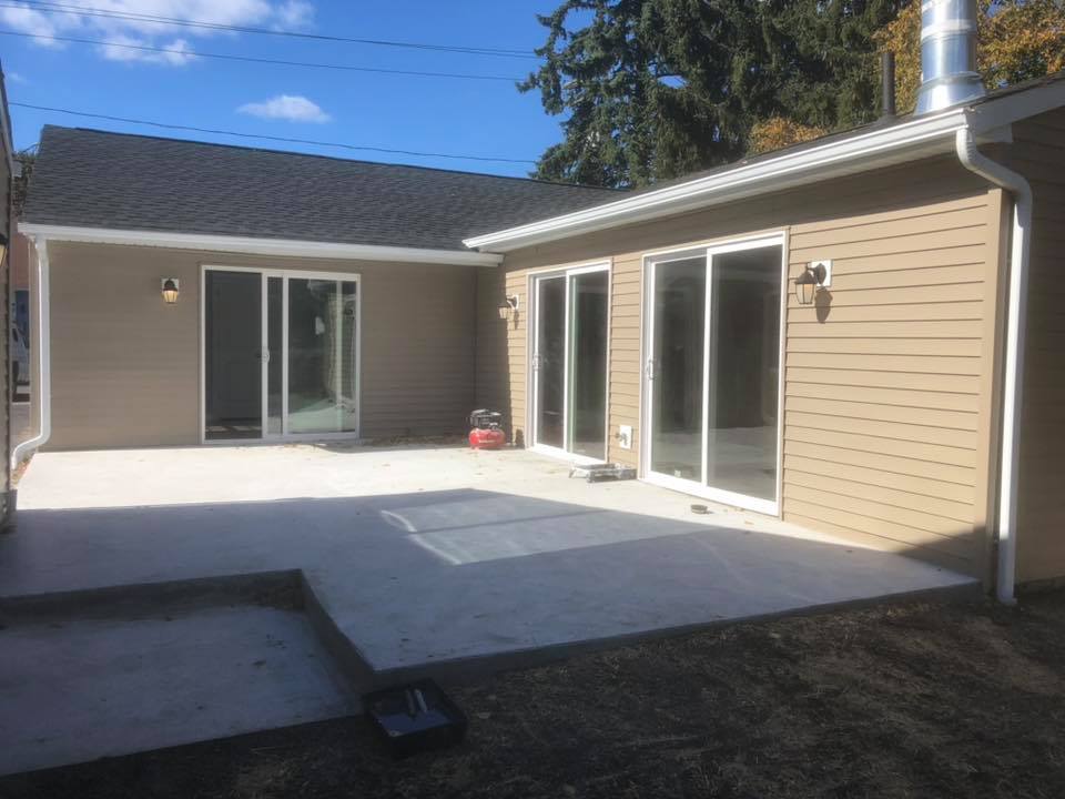 The backyard of a house with a patio and sliding glass doors.