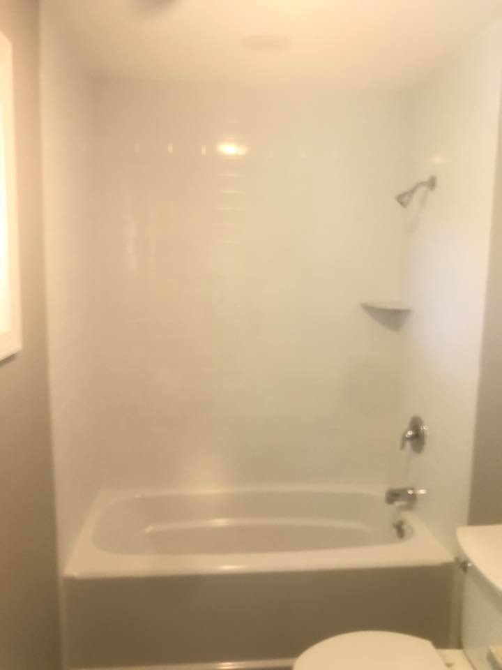 A bathroom with a bathtub , toilet and shower.