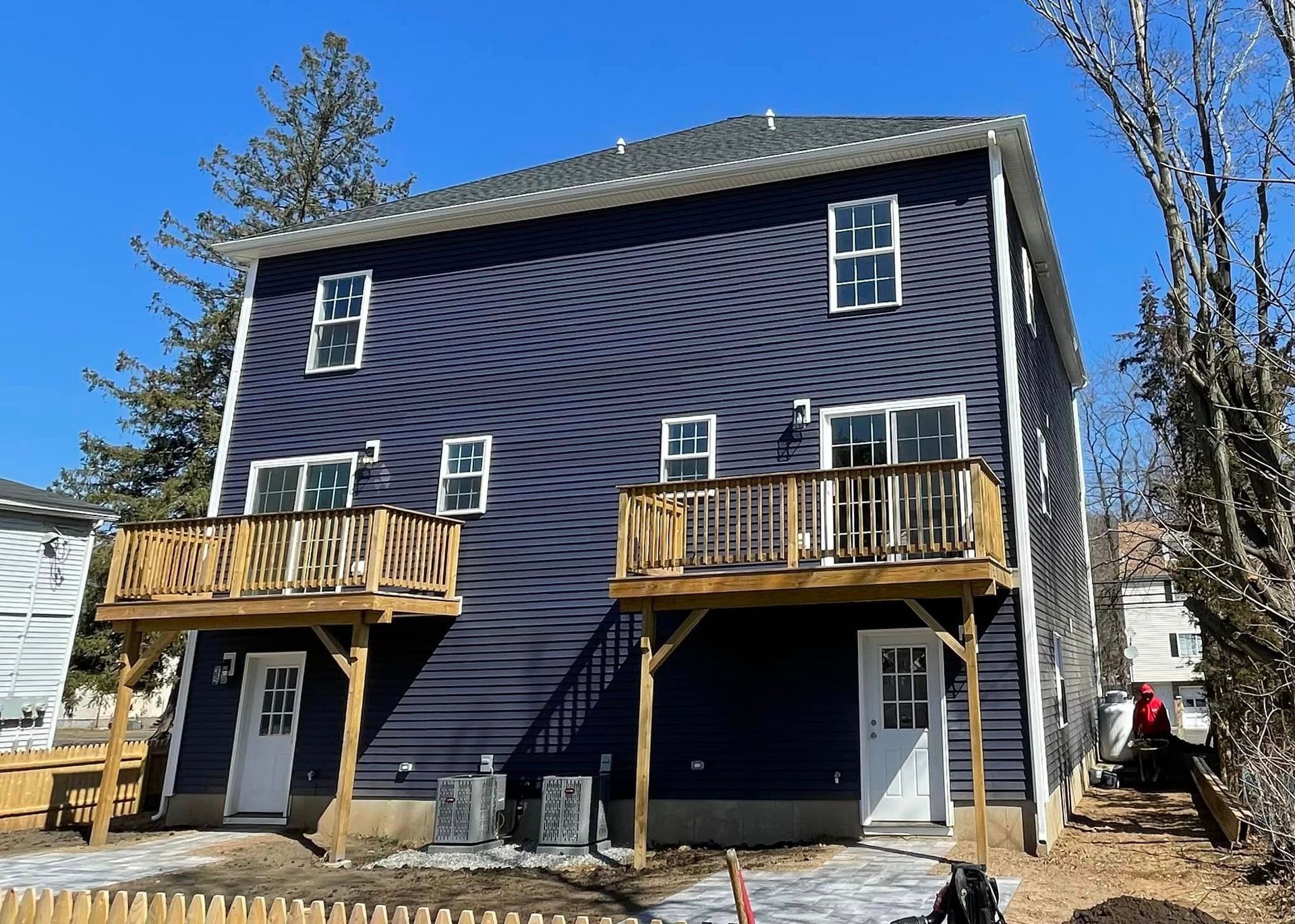 A purple house with a wooden deck and a blue sky in the background