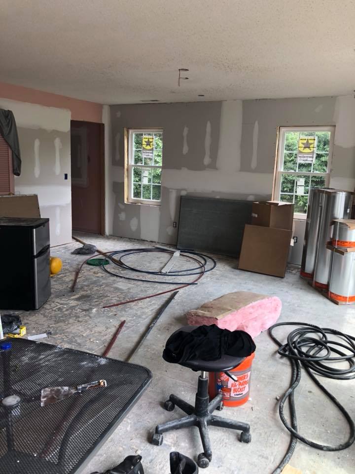 A room that is being remodeled with a lot of wires hanging from the ceiling.