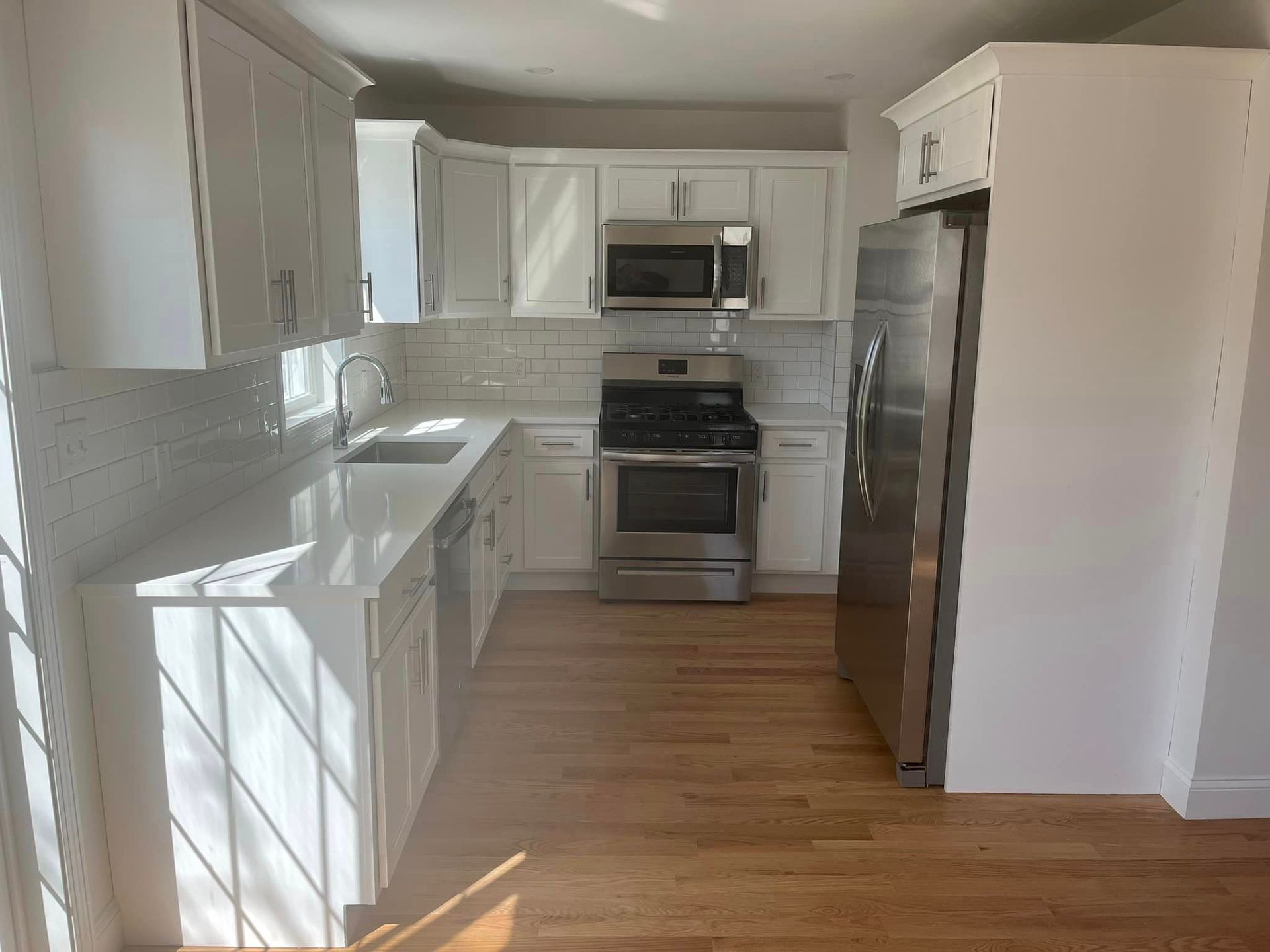A kitchen with white cabinets and stainless steel appliances