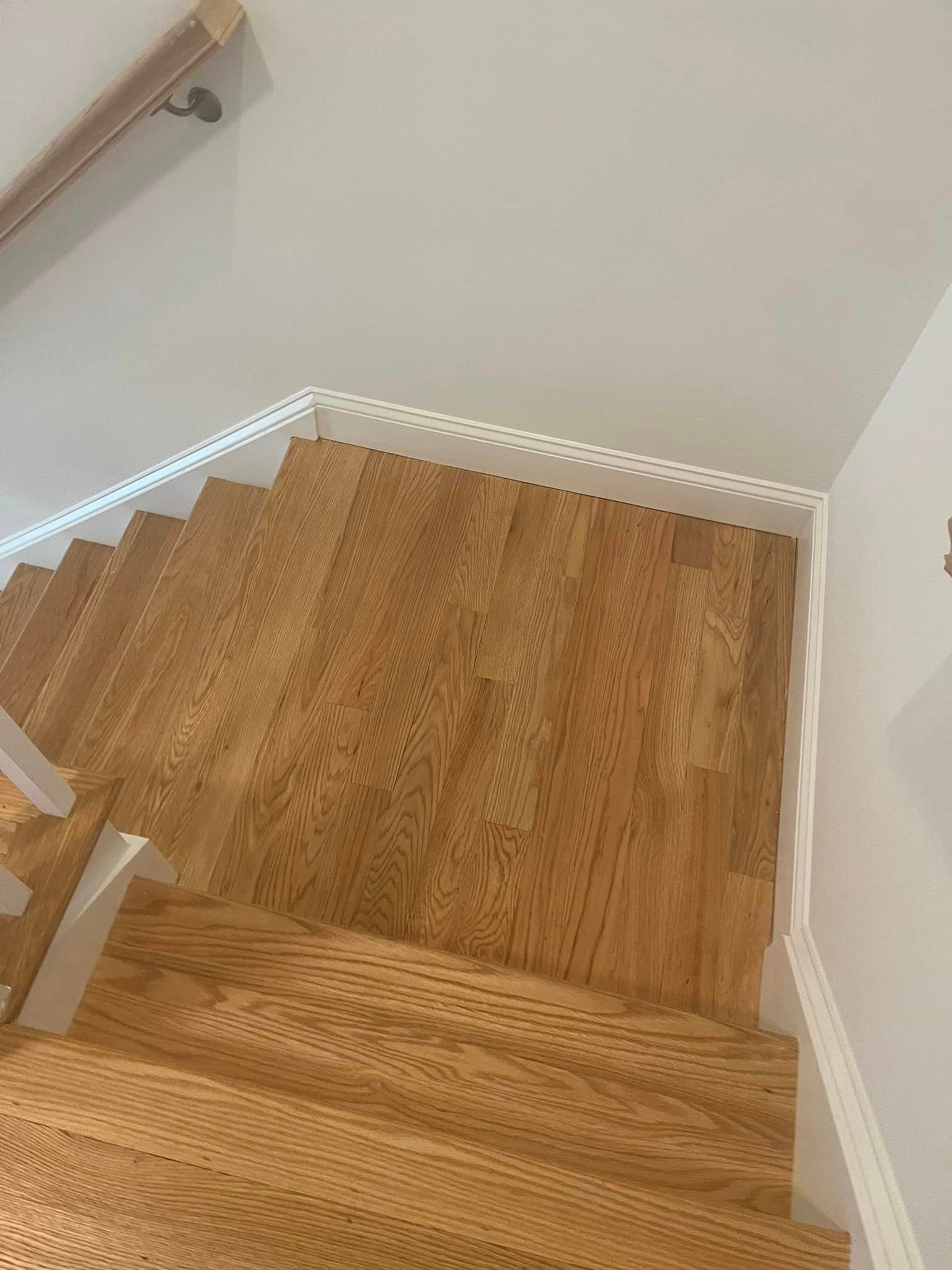 The stairs are made of hardwood and have a white railing.