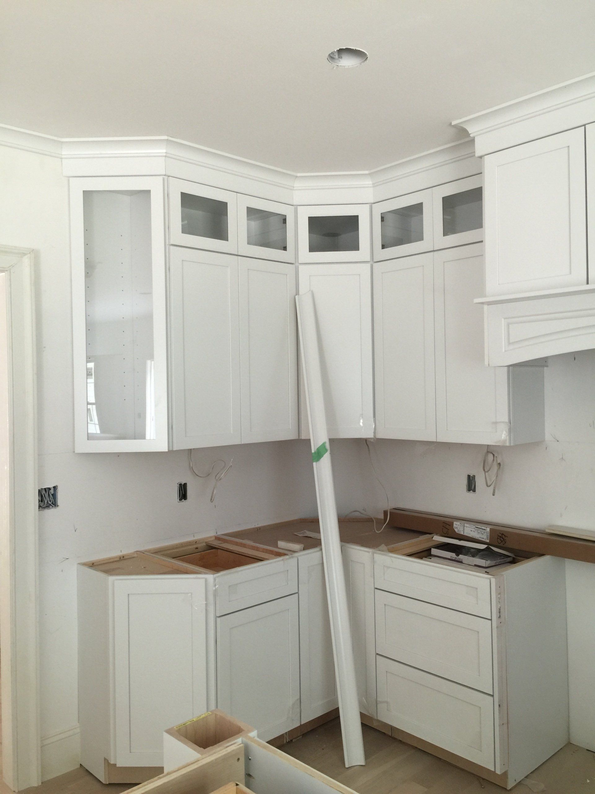 A kitchen with white cabinets and a ladder in the corner