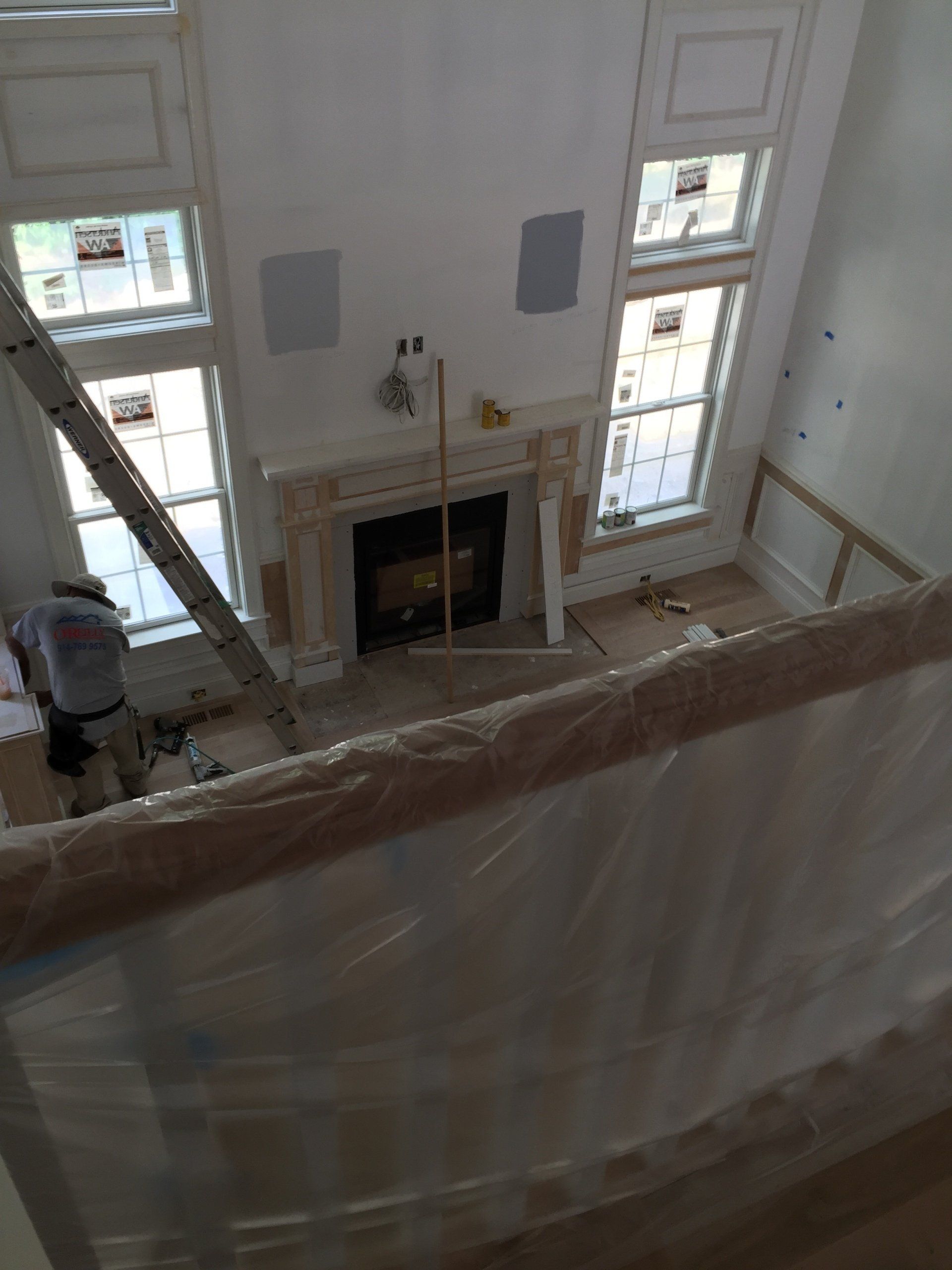 An aerial view of a living room with a fireplace and a ladder.